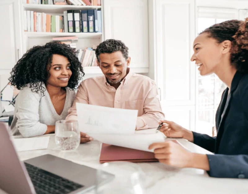 Financial advisor explaining home equity investment options to a couple at a desk.