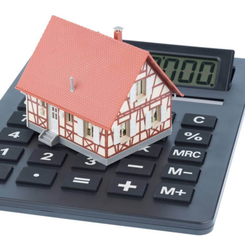 Decorative Image. Toy house on top of a calculator.